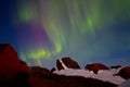 Arctic landscape with aurora. Northern lights (aurora borealis) over a rocky mountain peak Royalty Free Stock Photo