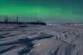 Arctic landscape with aurora. Northern lights (aurora borealis) over a snowy river valley. Royalty Free Stock Photo