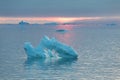 Arctic nature landscape with icebergs in Greenland icefjord with midnight sun sunset / sunrise in the horizon. Early morning