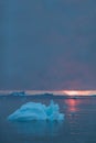 Arctic nature landscape with icebergs in Greenland icefjord with midnight sun sunset / sunrise in the horizon.  Early morning Royalty Free Stock Photo