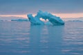 Arctic nature landscape with icebergs in Greenland icefjord with midnight sun sunset / sunrise in the horizon.  Early morning Royalty Free Stock Photo