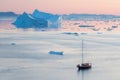 Arctic nature landscape with icebergs in Greenland icefjord with midnight sun sunset / sunrise in the horizon.  Early morning Royalty Free Stock Photo