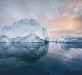 Arctic nature landscape with icebergs in Greenland icefjord with midnight sun sunset sunrise in the horizon. Early