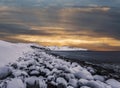 Arctic ocean with stones covered with ice and mountains on the horizon