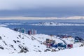 Arctic streets and building blocks of greenlandic capital Nuuk city at the fjord, view from snow hills, Greenland
