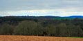 Ardennes landscape,with empty winter farmland and forests and hills on a rainy day with dark clouds Royalty Free Stock Photo