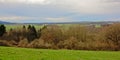 Ardennes landscape, rolling hills with evergreen and bare deciduous trees under dark clouds Royalty Free Stock Photo