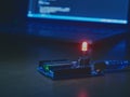 Arduino with Red Light-Emitting Diode Against a Laptop Screen