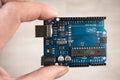 Arduino Uno board electronics in hand for programming the microcontroller