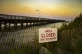 Area Closed Erosion Sign by Pier at Sunset Royalty Free Stock Photo