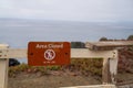 Area closed no hiking or access sign on fence block entry to cliff side of ocean water