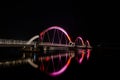 Areal shot of a bridge in the night, illuminated by vibrant purple lights Royalty Free Stock Photo