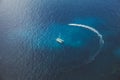 Areal view of catamaran boat in clear blue ocean water and jet scooter drives around boat. Calm beautiful waters. Royalty Free Stock Photo