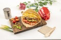 Arepa llanera with shredded beef, avocado, tomato, cheddar cheese and other condiments