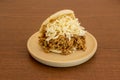 Arepa pelua stuffed to overflowing with shredded meat, cheese strips