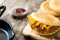 Arepa with shredded beef and cheese on wooden background. Venezuelan typical food Royalty Free Stock Photo