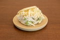 Arepa sifrina with lots of avocado, mayonnaise and grated cheese in a round resin plate