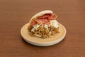 Arepa USA style with lots of shredded meat and lots of bacon with grated fresh cheese on a resin plate Royalty Free Stock Photo