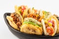 Arepas with assorted fillings served in a black ceramic dish Royalty Free Stock Photo