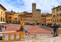 AREZZO, ITALY. Cityscape with Piazza Grande square in Arezzo with facade of old historical buildings and young woman re