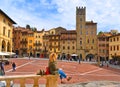 AREZZO, ITALY. Cityscape with Piazza Grande square in Arezzo with facade of old historical buildings and young woman re