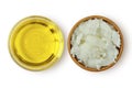 Argan oil in glass bowl and karitÃÂ© shea butter in wooden bowl on white background