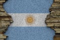 Argentina flag depicted in paint colors on old stone wall closeup. Textured banner on rock wall background Royalty Free Stock Photo