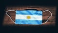 Argentina National Flag at medical, surgical, protection mask on black wooden background. Coronavirus CovidÃ¢â¬â19, Prevent Royalty Free Stock Photo