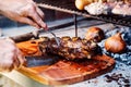 Argentine man cutting roast beef ribs. Asado from Argentina. Barbecue Royalty Free Stock Photo