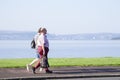 Senior obese couple walking at seaside on esplanade at Helensburgh