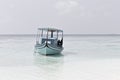 Ari Atoll, Maldives: A maldivian sailor is fishing on his blue boat called `dhoni`