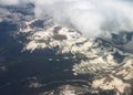 Arial view looking down on snow covered mountains shrouded with fog