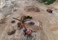 Arial view of the sand open-pit mining with heavy mining machinery. Mobile stone jaw crusher machine in open pit mine. Wheel