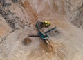 Arial view of the sand open-pit mining with heavy mining machinery. Mobile stone jaw crusher machine in open pit mine. Wheel