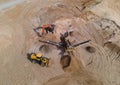 Arial view of the sand open-pit mining with heavy mining machinery. Mobile stone jaw crusher machine in open pit mine. Wheel