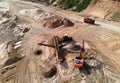 Arial view of the sand open-pit mining with heavy mining machinery. Mobile stone jaw crusher machine in open pit mine. Wheel
