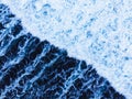 Arial view of splashing oceanic waves with bubbles and foam