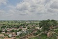 An Arial view of a village, a train moving forward with dramatic cloud formation