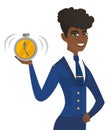 Arican-american stewardess holding alarm clock.