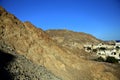 Arid degrading mountain range, with watchtower, around the city of Matrah, under the blue sky, Muscat, Oman Royalty Free Stock Photo