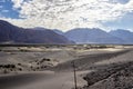 Arid dry dessert sand dunes of nubra valley with himalayan barren mountain range in the background at ladakh, Kashmir, india Royalty Free Stock Photo