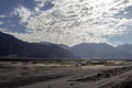 Arid dry dessert sand dunes of nubra valley with himalayan barren mountain range in the background at ladakh, Kashmir, india Royalty Free Stock Photo