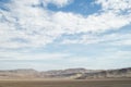 Arid lands of the desert under blue cloudy sky Royalty Free Stock Photo