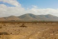 Arid region dry soil with rounded mountains on the background panoramic view on Furteventura Island