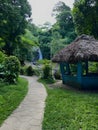 path passing through a park with a hut moving towards a water fall Royalty Free Stock Photo