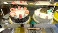 arious Cake with Icing in Refrigerated Bakery Case Cabinet - Image