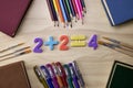 arithmetic example 2 plus 2 equals 4 on the table around the book pencils fountain pens the concept of education school Royalty Free Stock Photo