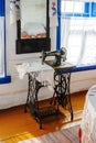 Old mechanical sewing machine with foot drive by Singer firm in the interior of an old Cossack estate