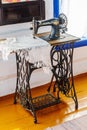 Old mechanical sewing machine with foot drive by Singer firm in the interior of an old Cossack estate