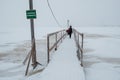 ARKHANGELSK, RUSSIA - JANUARY 06 2022: A girl with a pram crosses an ice-hole on a wooden bridge Royalty Free Stock Photo